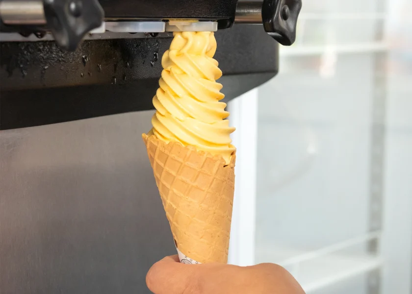 Bee Sweet Creamery Yellow Soft Serve Ice Cream in a Cone from a Machine